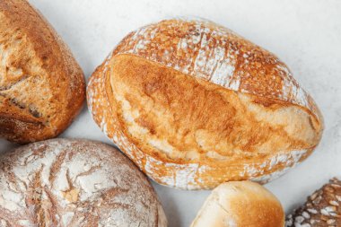 Yüzeyde farklı türde taze pişmiş zanaatkar ekmeği bir arada sergilenir..