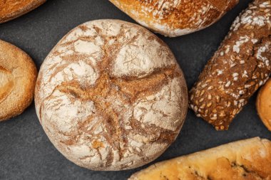 Koyu bir yüzeyde çeşitli zanaatkar ekmekler sergileniyor, dokularını sergiliyorlar..