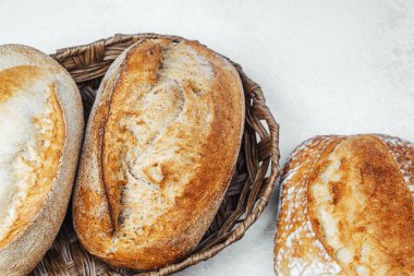 Üç zanaatkar ekmek somunu tezgahın üstünde hasır bir sepete konur..