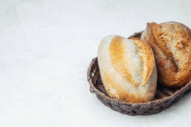 İki altın-kahverengi somun ekmeği dokuma sepetine yerleştirilir..