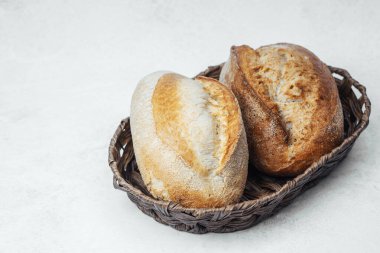 Tezgahın üzerinde dokuma sepetinde dinlenen iki ekmek somunu..
