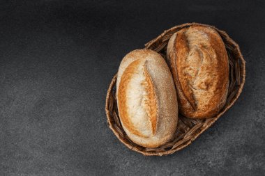 İki altın-kahverengi somun ekmeği dokuma sepetine yerleştirilir..