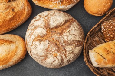 Değişik şekil ve boyutlarda kırsal ekmekler bir yüzeyde güzel bir şekilde düzenlenmiştir..