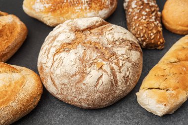 Çeşitli şekillerde taze ekmek somunları ve dokular birlikte sergileniyor..