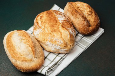 İşaretli kumaş üzerinde üç çeşit zanaatkar ekmek, kabuklu dokularını sergiliyor..