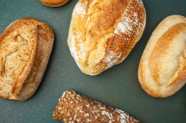 Kırsal bir yüzeyde doğal ışıkla sıralanmış çeşitli ekmekler..