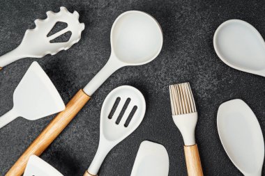 Ahşap saplı çeşitli seramik mutfak aletleri düzenli bir şekilde yerleştirilmiş..