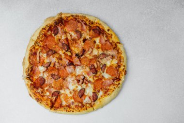 Erimiş peynir ve lezzetli malzemelerle kaplı taze pişmiş pepperoni pizza..