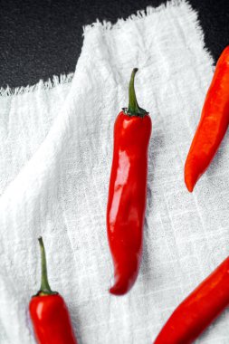 Parlak kırmızı biberler canlı renklerini ve şekillerini gösteren beyaz bir beze konur..