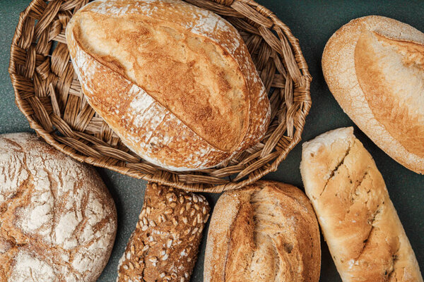 Массив различных типов хлеба отображается в корзине на темном фоне.