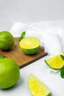 Parlak yeşil limon ve nane yaprakları ahşap bir tahtada ustalıkla düzenlenir..
