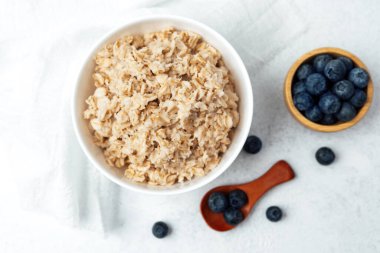 Yulaf ezmesi, pürüzsüz bir yüzey üzerinde taze yaban mersiniyle servis edilir..