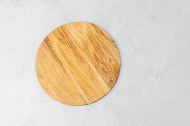 Basit yuvarlak bir tahta kesme tahtası hafif bir zeminde oturur, yemek pişirmek için mükemmeldir..