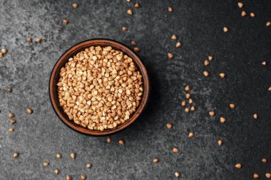 Kenarlarına biraz tohum serpiştirilmiş bir kasede susam tohumlarının yakın plan çekimi..