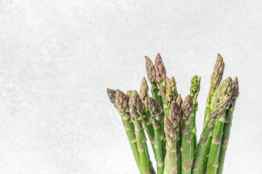 Tarafsız bir arkaplana karşı dik duran taze kuşkonmaz tazeliğini vurgular.