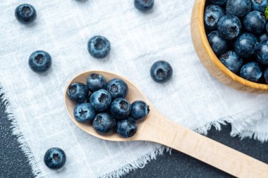 Sulu yaban mersinleri ahşap bir kaşıkta ve keten bir kasede sıralanır..