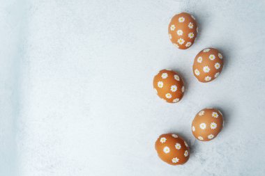 El boyaması Paskalya yumurtaları ve hafif arka planda papatyalar. Paskalya arka planı. 
