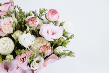 Zarif bir şekilde sergilenmek üzere hazırlanmış pembe ve beyaz bir buket çiçek..