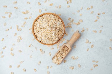 Yulaf dolu ahşap kase ve arka planda hafif bir kepçe..