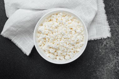 Koyu bir yüzeye keten bir bezle yerleştirilmiş bir kasede kremsi süzme peynir..