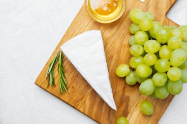 Tahtada peynir, taze yeşil üzüm ve bal var..