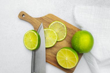 Limonlar tahta bir tahtada dilimlenir. Temiz bir mutfak tezgahında bıçakla..