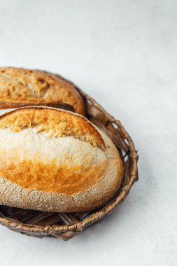 İki kabuklu ekmek, arka planda bir sepete konur..