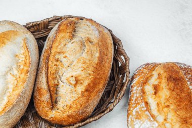 Üç zanaatkar ekmek somunu tezgahın üstünde hasır bir sepete konur..