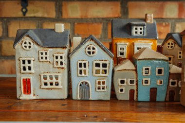 Sıcak bir atmosferde ahşap bir rafta seramik renkli evler sergileniyordu..