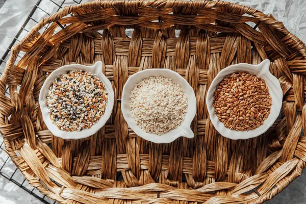 Örülmüş bir tepside kaselerde sergilenen farklı tohum türleri