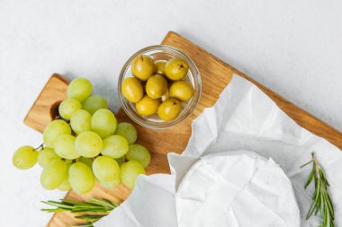 Tahtaya dizilmiş, yemeğe hazır üzüm, zeytin ve peynir..