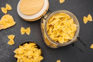 Farfalle makarnası kavanozu ustalıkla yerleştirilmiş parçalarla doldurur..