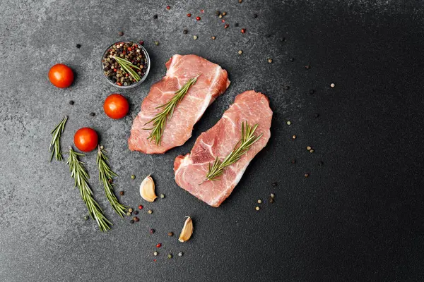 İki parça taze et biberiye ile süslenmiş ve sebze ve baharatla çevrili..