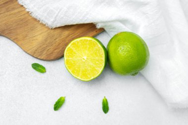 Nane yapraklı parlak renkli limonlar hazırlanmak için desenli bir arka plana yerleştirilir..