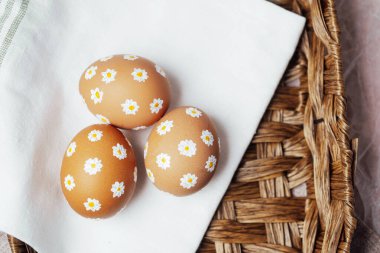 Elle boyanmış papatya çiçekli Paskalya yumurtaları. Yumuşak doğal ışıkta sanatsal bahar süslemesi