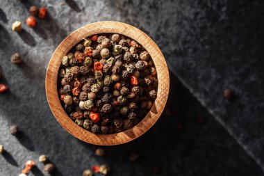 Ahşap bir kase biber güneş ışığıyla aydınlatılır..