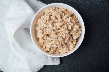 Kremalı yulaf ezmesi kahvaltı zamanı beyaz bir bezle çevrili bir kasede servis edilir..