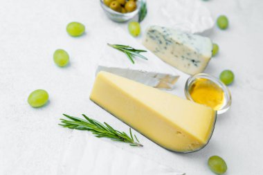 Zeytin ve taze üzümlerle sergilenmiş çeşitli peynirler, canlı bir yayılma yaratır..