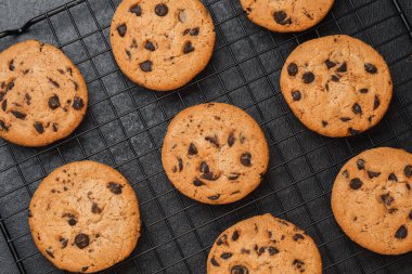 Sıcak çikolatalı kurabiyeler pişirdikten sonra siyah tel askıda soğuyor..