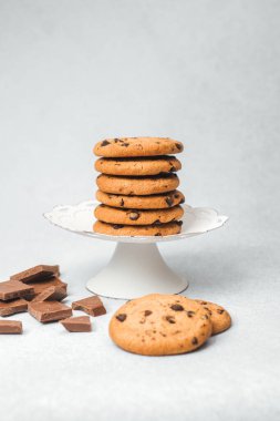 Lezzetli çikolatalı kurabiyeler, beyaz pasta standında güzelce yerleştirilmiş..