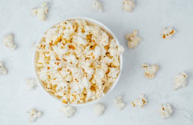 Hafif bir yüzeyde dağınık çekirdekli yumuşak patlamış mısırla dolu bir kase..