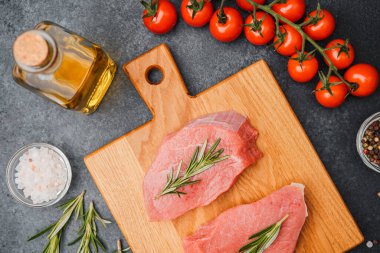 Biberiyeli dana bifteği, ahşap kesim tahtası ve yemek malzemesi.