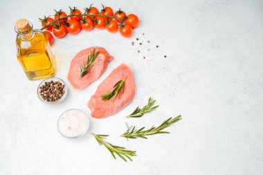 Beyaz arka planda baharatlı dana bifteği ve bitkilerin üst görüntüsü, yakın plan yağ ve biber dahil.