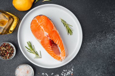 Limonlu, zeytinyağlı ve baharatlı bir tabakta sergilenmiş somon filetosu..