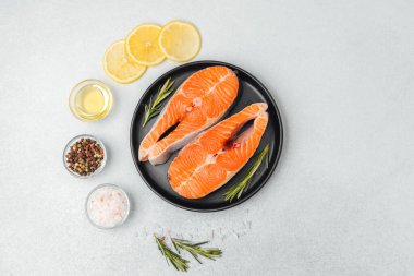 Limon dilimleri ve bitkilerle hazırlanmış iki somon filetosu..