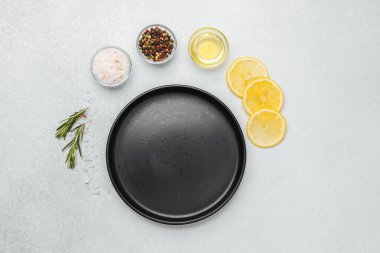 Taze limon dilimleri, otlar, baharatlar ve yağ yemek hazırlıkları için hazır..