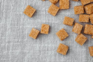 Esmer şeker küpleri gelişigüzel bir şekilde kumaş kumaşa yerleştirilir, pişirmek için idealdir..