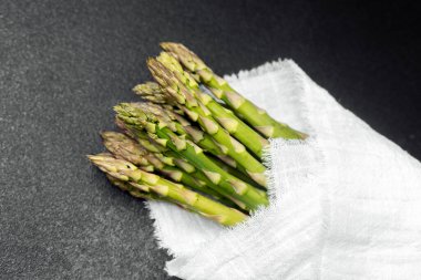 Taze kuşkonmaz mızrakları bir kumaşa sarılmış, pişirmeye ya da servis etmeye hazır..