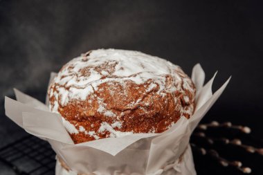 Geleneksel Paskalya pastası, üzerinde pudra şekeri olan koyu masa. Bahar kutlaması kavramı