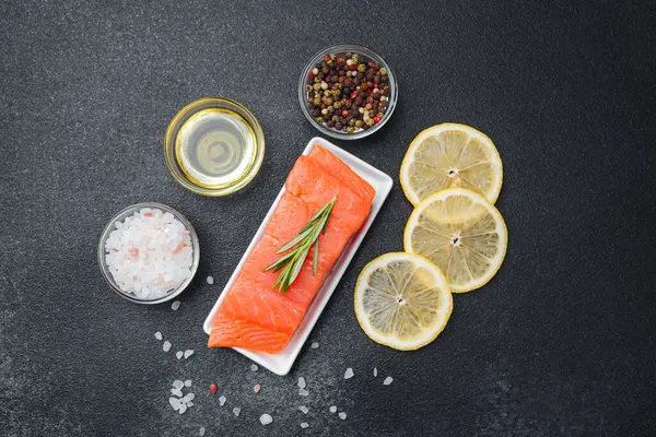 Somon filetosu baharatlar, limon dilimleri ve yemek hazırlamak için yağ ile düzenlenir..